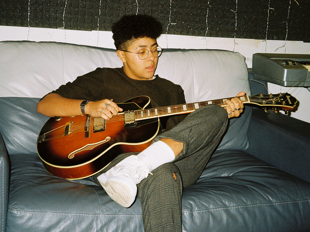 A young person playing guitar